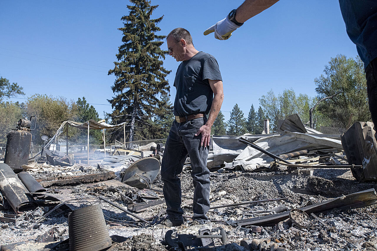 Jim Murray surveys his house, which was destroyed by a wildfire, in September, 2020, in Malden. “I bought this house about 5 years ago to retire here. My grandfather ran the town gas station, was the town cop at one time and was the fire chief,” said Murray. “My wife and I planned to retire here but I’m not sure I am going to rebuild. I have a feeling this is going to be a ghost town now.” (Jed Conklin / Associated Press)