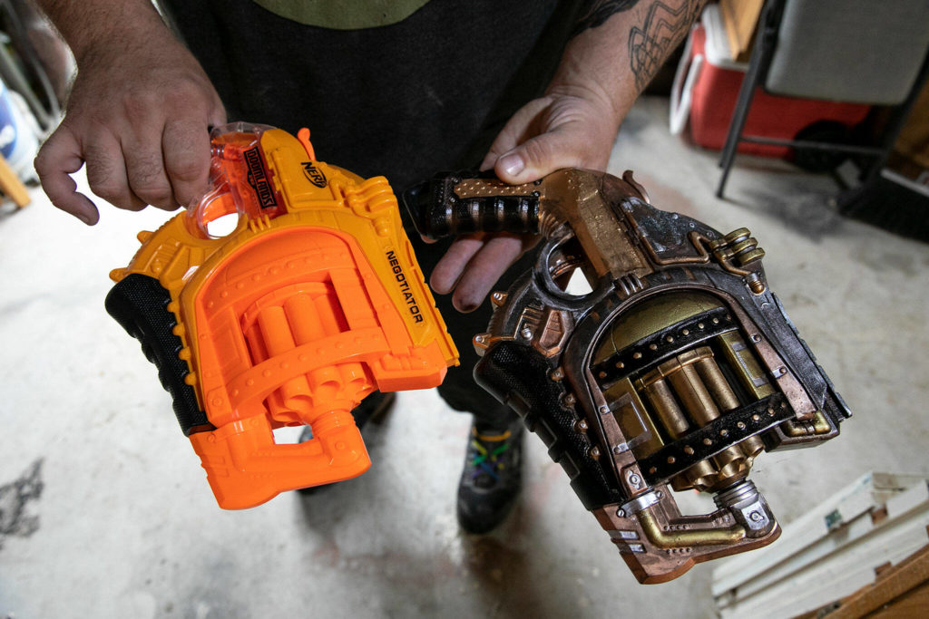 Josh Haazard holds two Nerf guns of the same model — one untouched and the other modified in his HaazLab. (Ryan Berry / The Herald)
