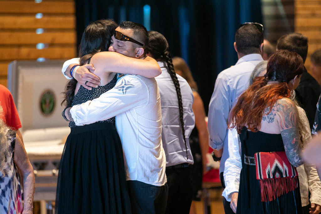 Mourners embrace during the viewing segment of a memorial service for Terry Williams on Saturday at the Tulalip Gathering Hall in Tulalip. (Ryan Berry / The Herald)

