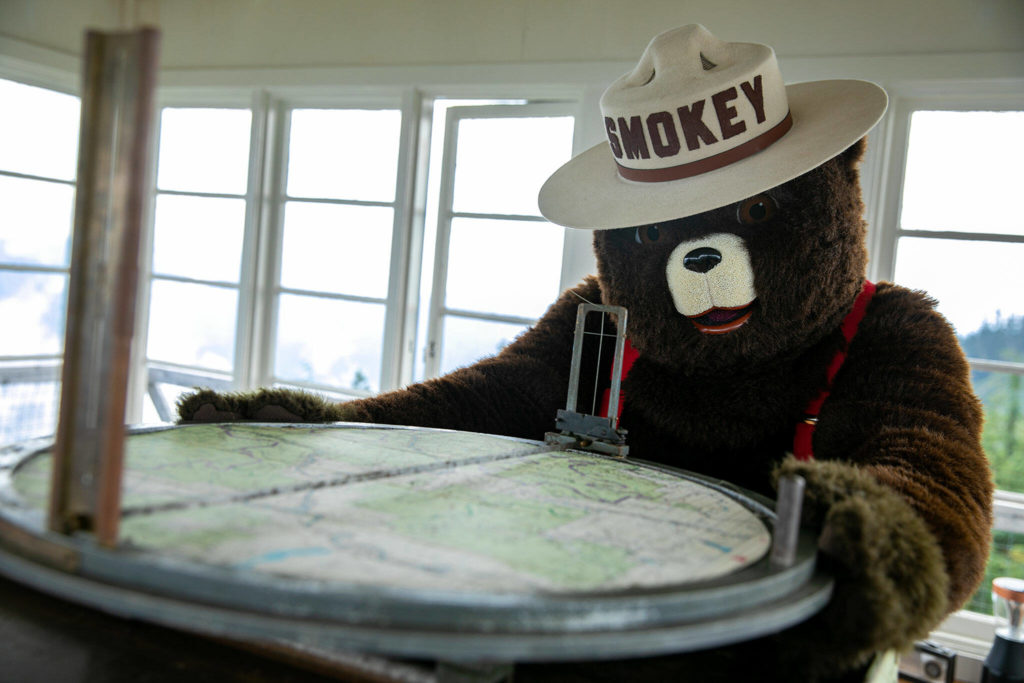 Smokey Bear takes a look at an Osborne Fire Finder Wednesday, at the North Mountain Fire Lookout north of Darrington. (Ryan Berry / The Herald)
