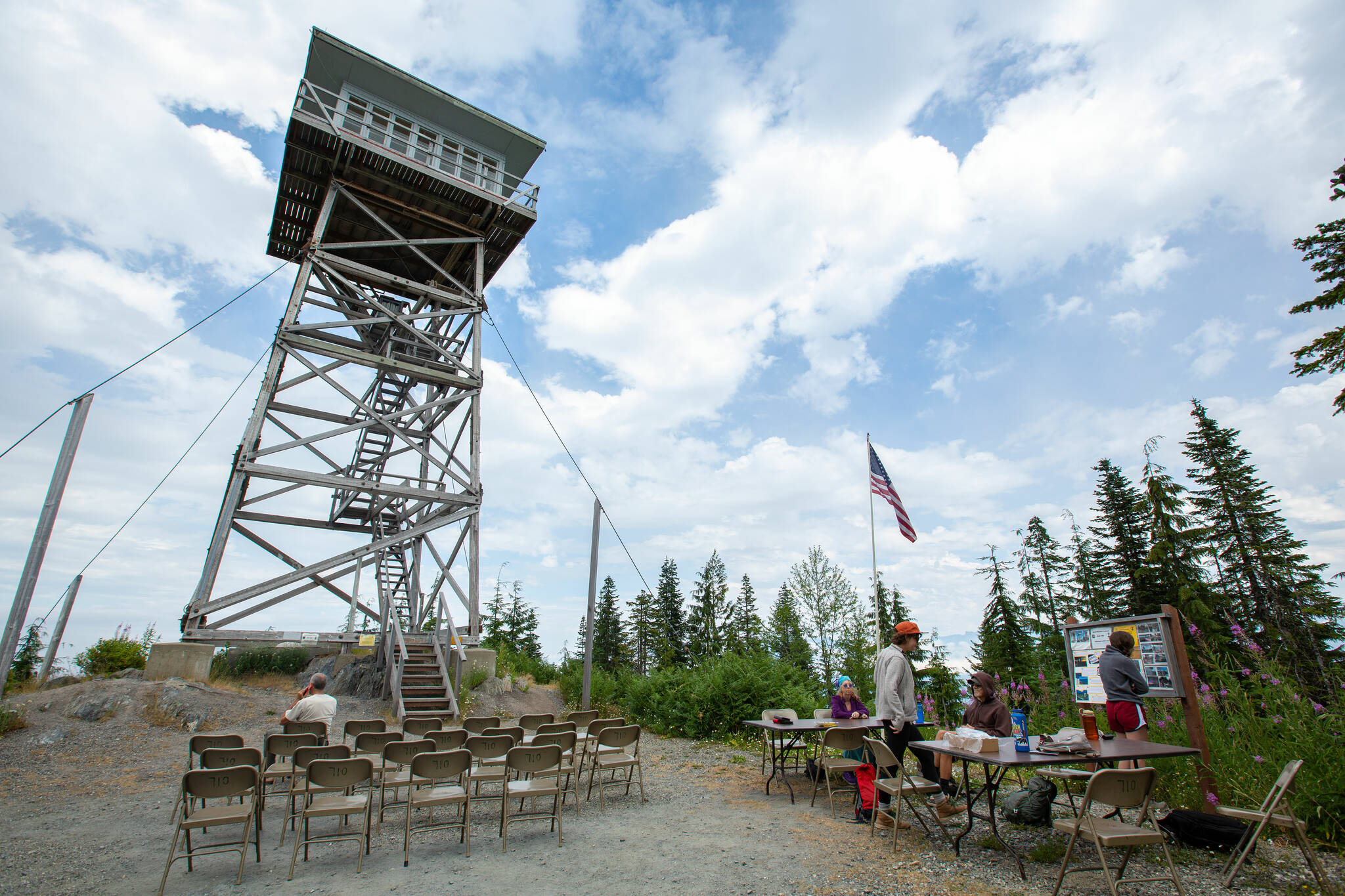 People begin to gather on Wednesday, Aug. 10, 2022, at the North Mountain Fire Lookout north of Darrington, Washington. (Ryan Berry / The Herald)