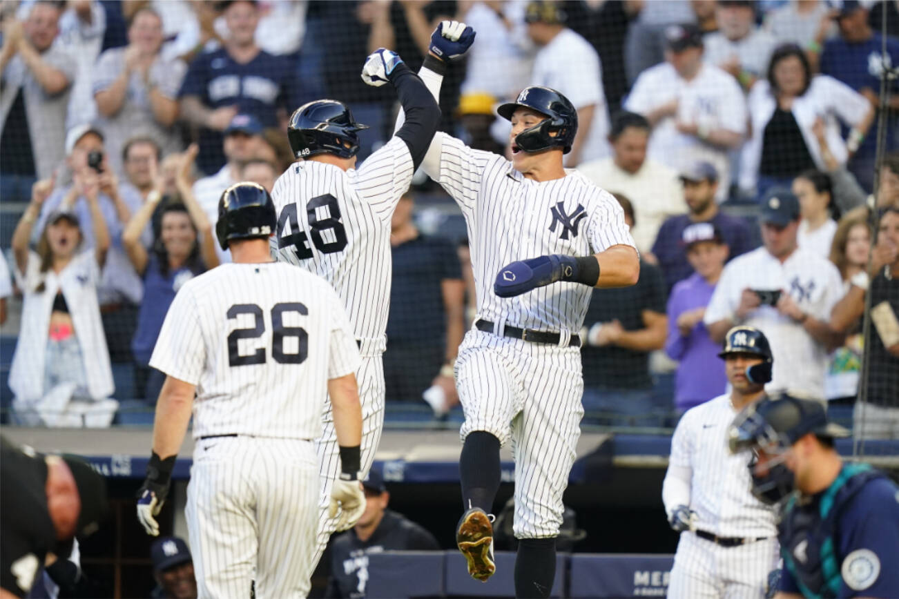 New York Yankees' DJ LeMahieu (26) looks on as Anthony Rizzo (48) celebrates with Aaron Judge after Rizzo hit a three-run home run during the first inning of a baseball game against the Seattle Mariners, Monday, Aug. 1, 2022, in New York. (AP Photo/Frank Franklin II)