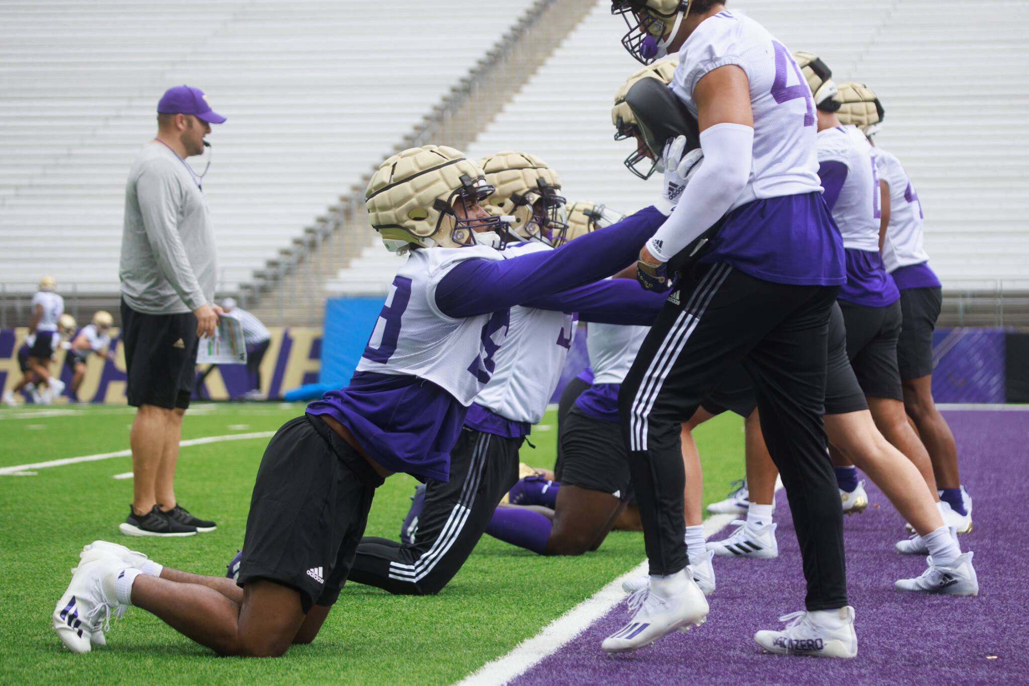 Washington edge Zion Tupuola-Fetui (front left) and teammates take part in the team’s fist preseason practice on Thursday at Husky Stadium in Seattle. (Erika Schultz/The Seattle Times via AP)