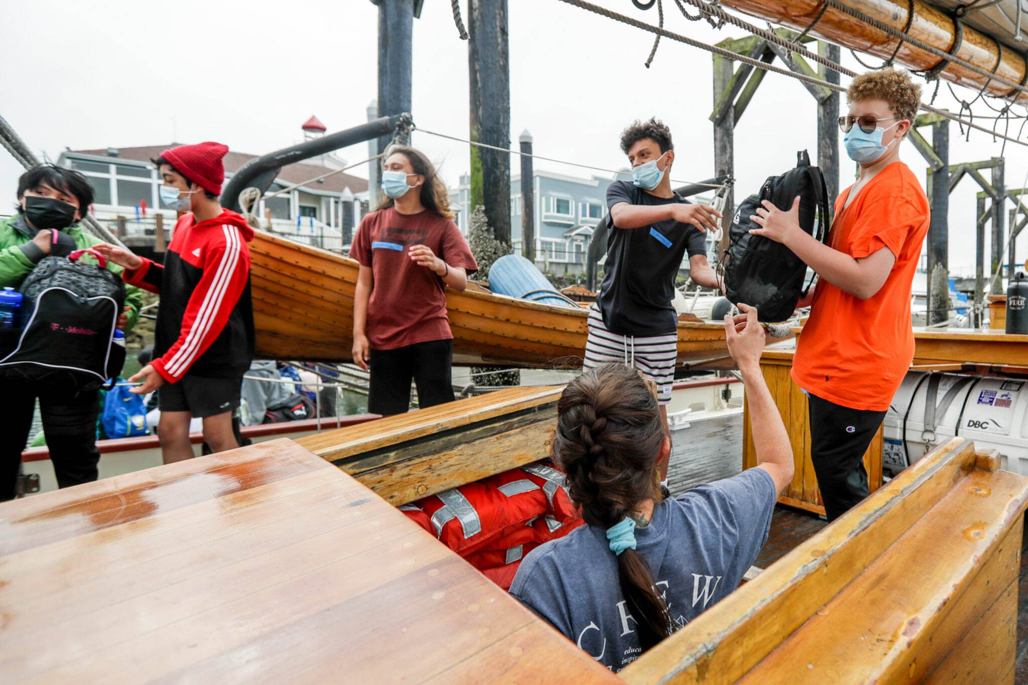 Members of Casino Connect line up to stow luggage Tuesday morning aboard the Adventuress in Everett. The teens will go on a four-day sailing trip where they learn about maritime skills and environmental science. (Kevin Clark / The Herald)