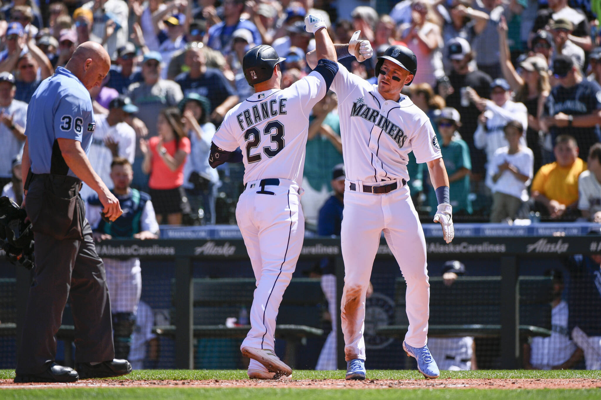 The Mariners’ Ty France (23) celebrates at the plate with Jarred Kelenic after hitting a two-run home run during the third inning of a game against the Angels on Saturday in Seattle. (AP Photo/Caean Couto)