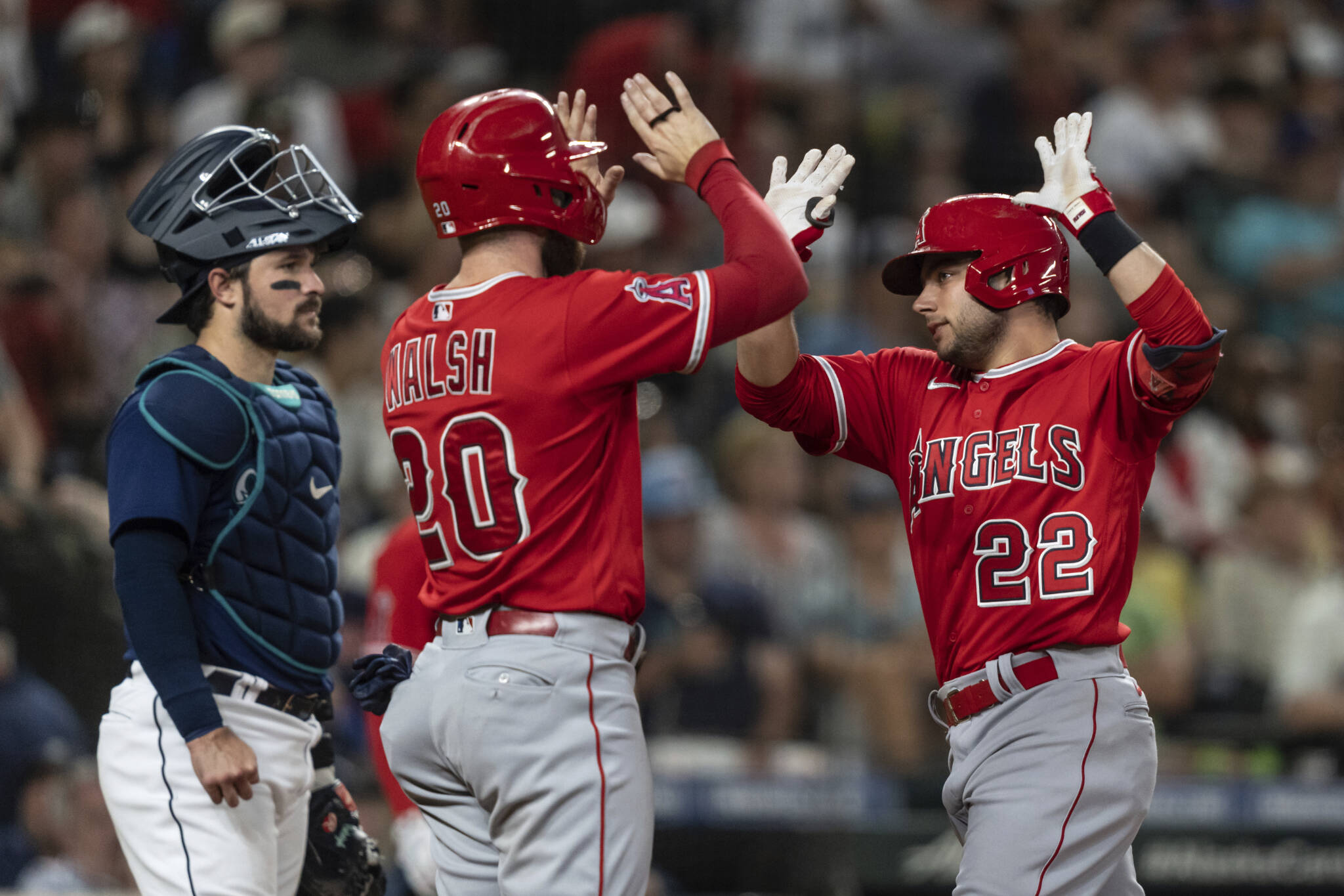 The Angels’ David Fletcher (right) is congratulated by Jared Walsh after hitting a two-run home run during the sixth inning in the second game of a doubleheader Saturday in Seattle. Walsh scored on the homer. (AP Photo/Stephen Brashear)