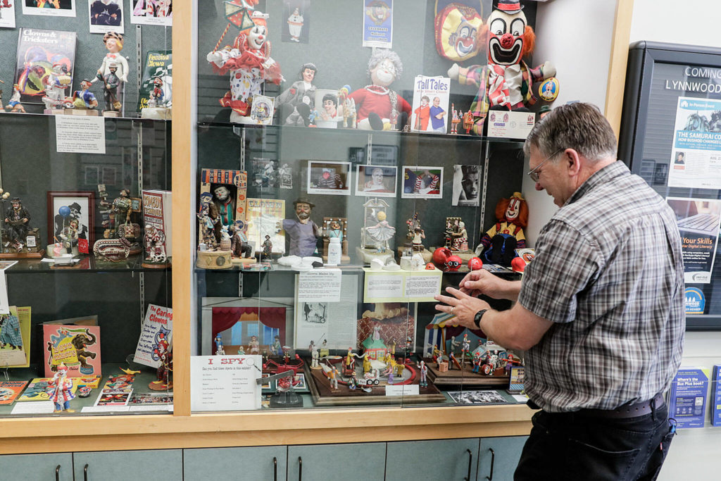 Bruce Johnson has an exhibit on the history of clowns at the Lynnwood Library on Thursday in Lynnwood. (Kevin Clark / The Herald)
