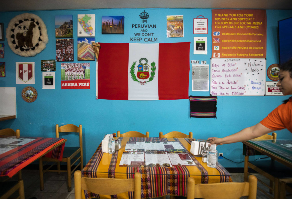 A wall covered in Peruvian photos, flags and other items at Rinconcito Peruano Restaurant on Saturday, in Lynnwood. (Olivia Vanni / The Herald) 
