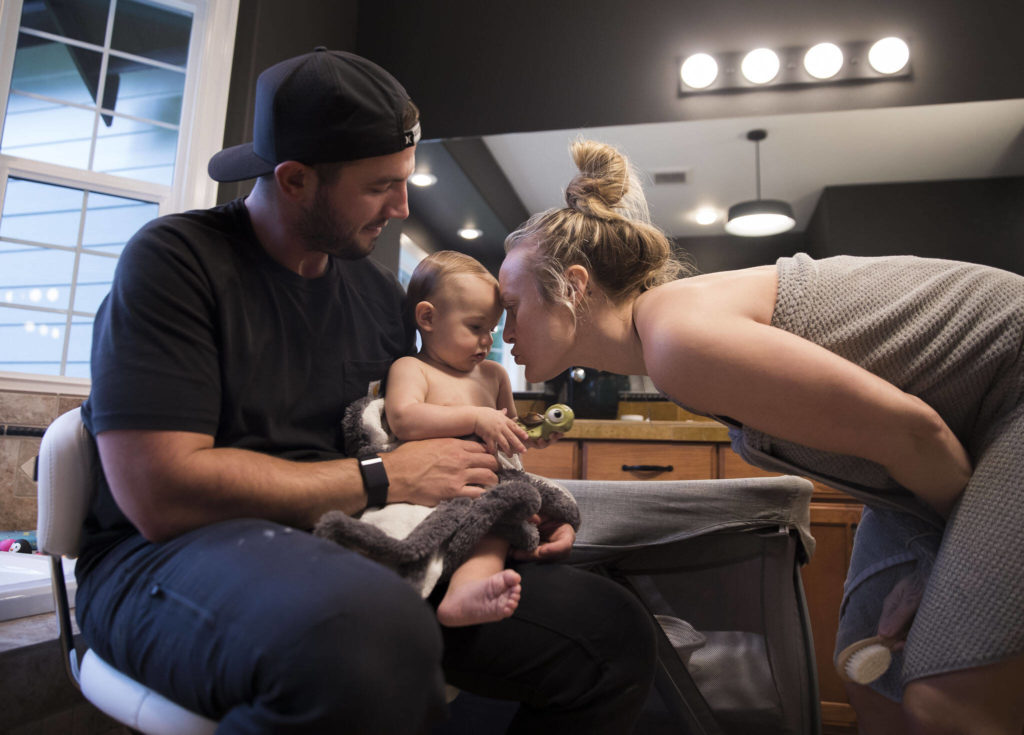 Kaden Barish holds his daughter Austin while her mother Miranda Granger bends down to kiss her after a bath on Monday, May 16, 2022, in Lake Stevens, Washington. (Olivia Vanni / The Herald)
