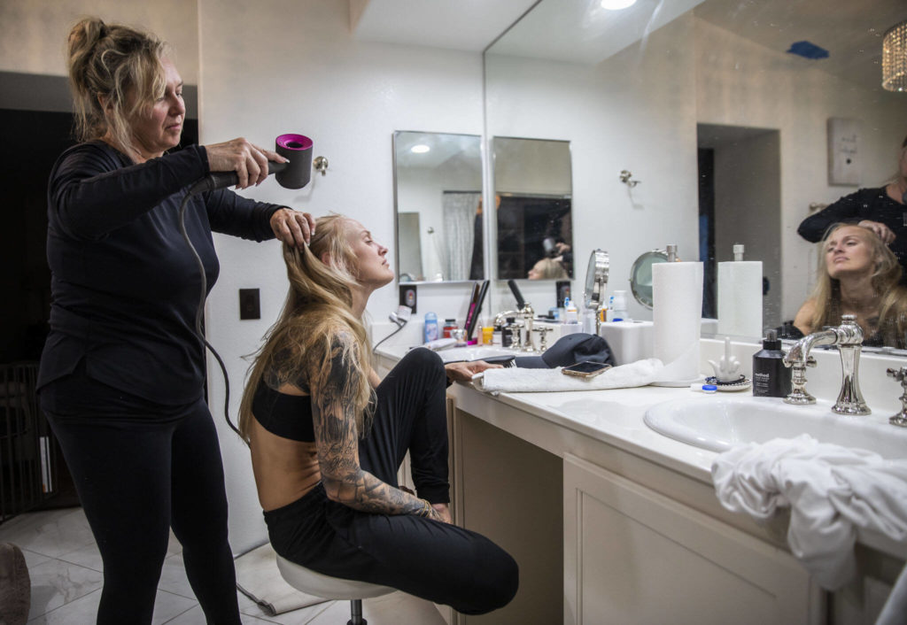 Cheryl Granger, left, Miranda Granger’s mother, dries and brushes her hair after her post-weight cut shower Thursday, Aug. 4, 2022, in Las Vegas. Granger’s mother always brushes and dries her hair the evening of a weight cut because the fighter is normally too exhausted to do so herself. (Olivia Vanni / The Herald)
