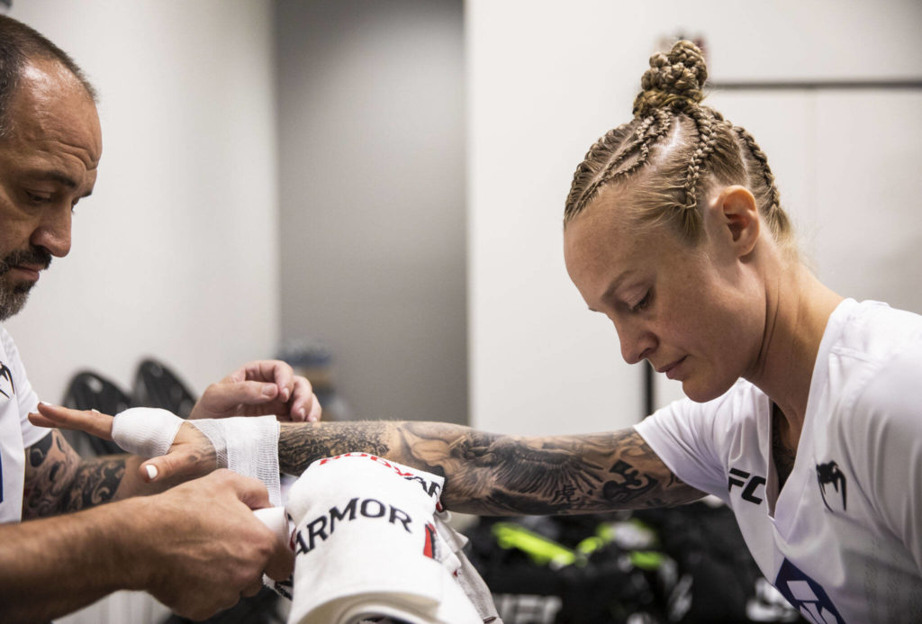 Coach and lead corner Charlie Pearson, left, wraps Miranda Granger’s hands before her fight at the UFC Apex on Aug. 6, 2022, in Las Vegas. Pearson has been Granger’s coach since she was 4 years old. He has wrapped her hands before all of her professional fights. (Olivia Vanni / The Herald)

