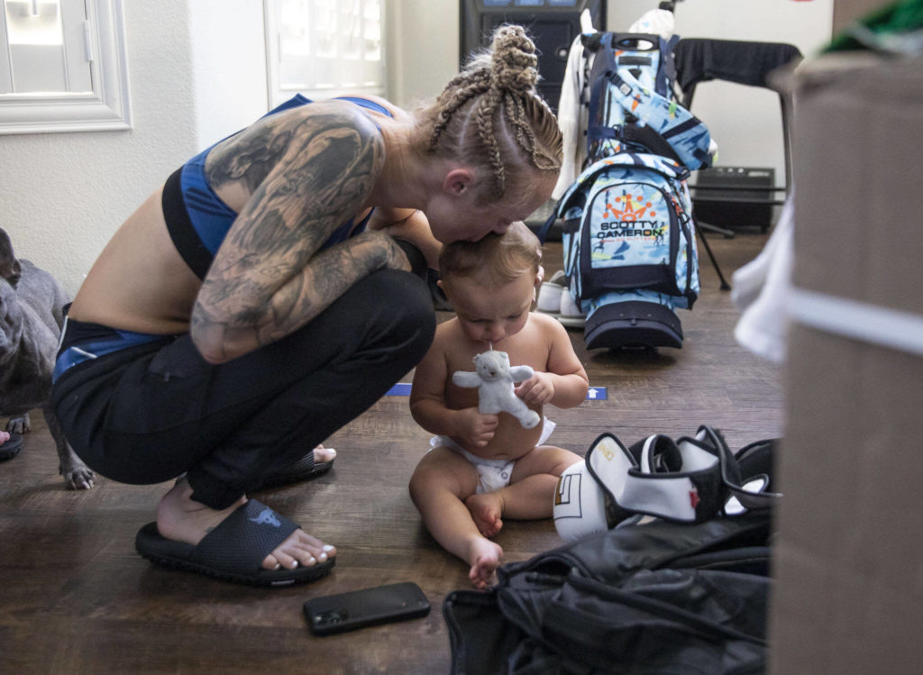 Miranda Granger squats and kisses Austin on the head with tears in her eyes after losing her fight against Cory McKenna at the UFC Apex on Aug. 6, 2022, in Las Vegas. (Olivia Vanni / The Herald)
