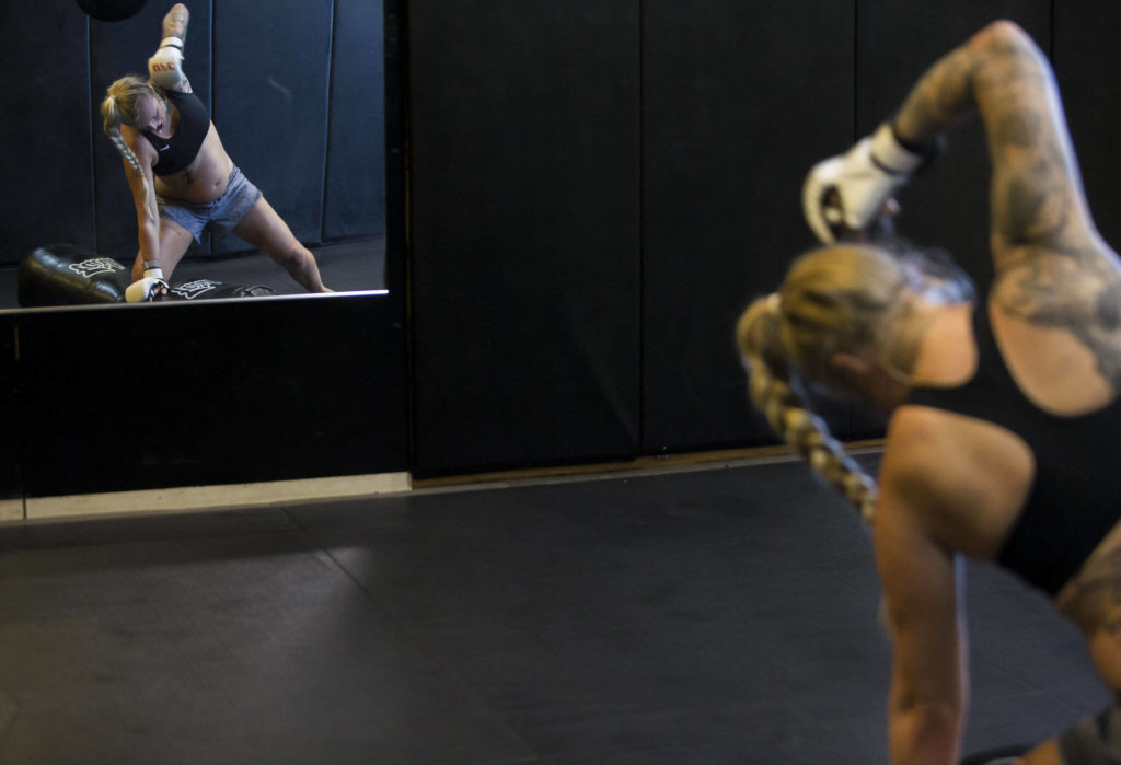 Miranda Granger raises her fist up to punch a grappling dummy during one of her workouts at Charlie’s Combat Club on Thursday, May 13, 2022, in Everett, Washington. (Olivia Vanni / The Herald)
