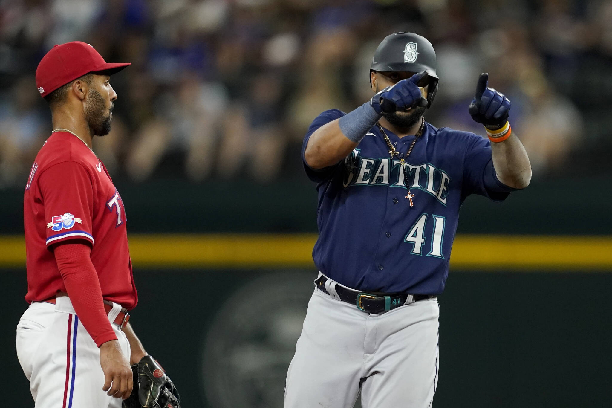 The Mariners’ Carlos Santana (41) celebrates his double next to Rangers second baseman Marcus Semien during the fourth inning of a game Friday in Arlington, Texas. (AP Photo/Tony Gutierrez)