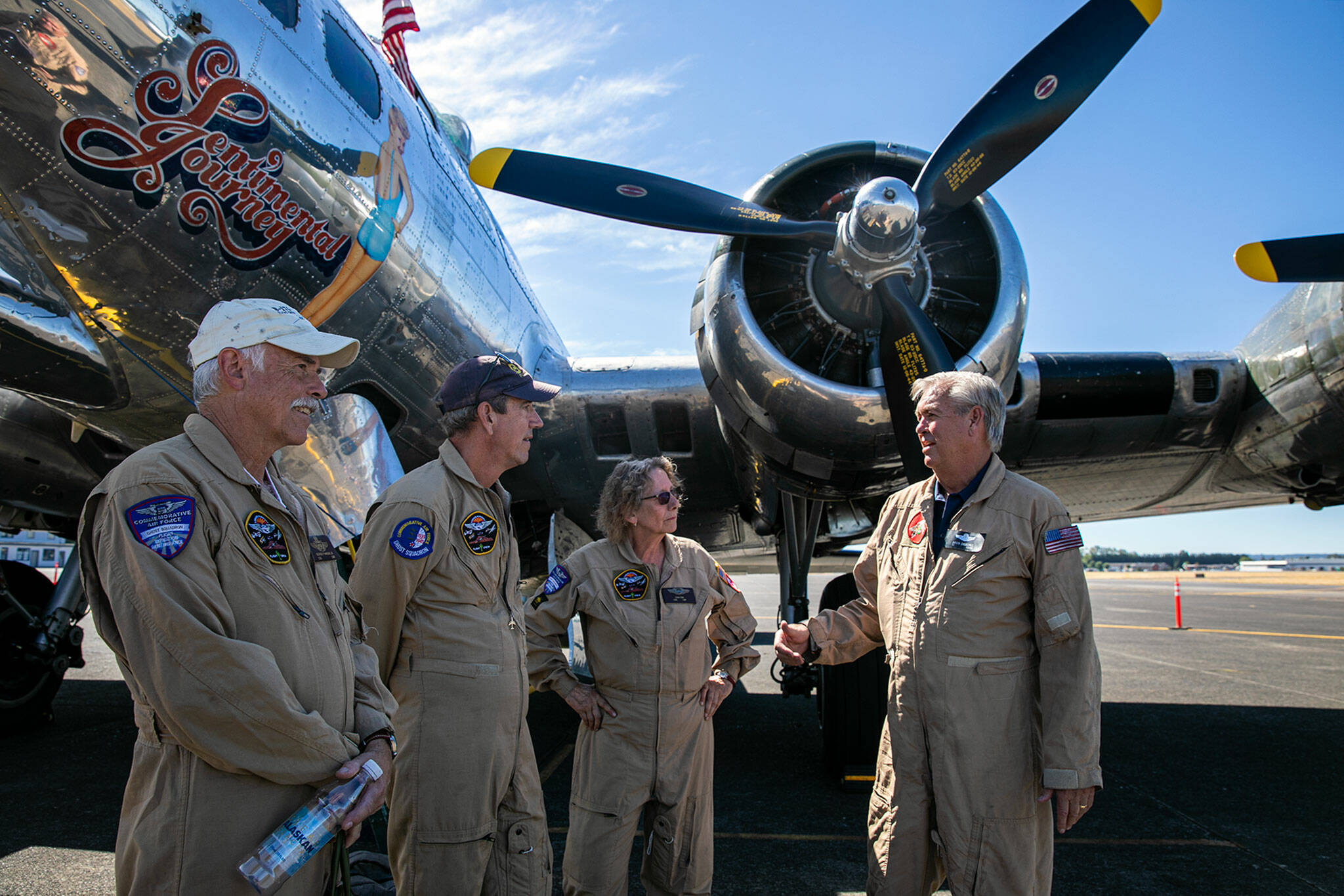 Commemorative Air Force crew members stand beside Sentimental Journey, a Boeing B-17 Flying Fortress, after landing the WWII-era bomber on Monday, at Arlington Municipal Airport in Arlington. (Ryan Berry / The Herald)