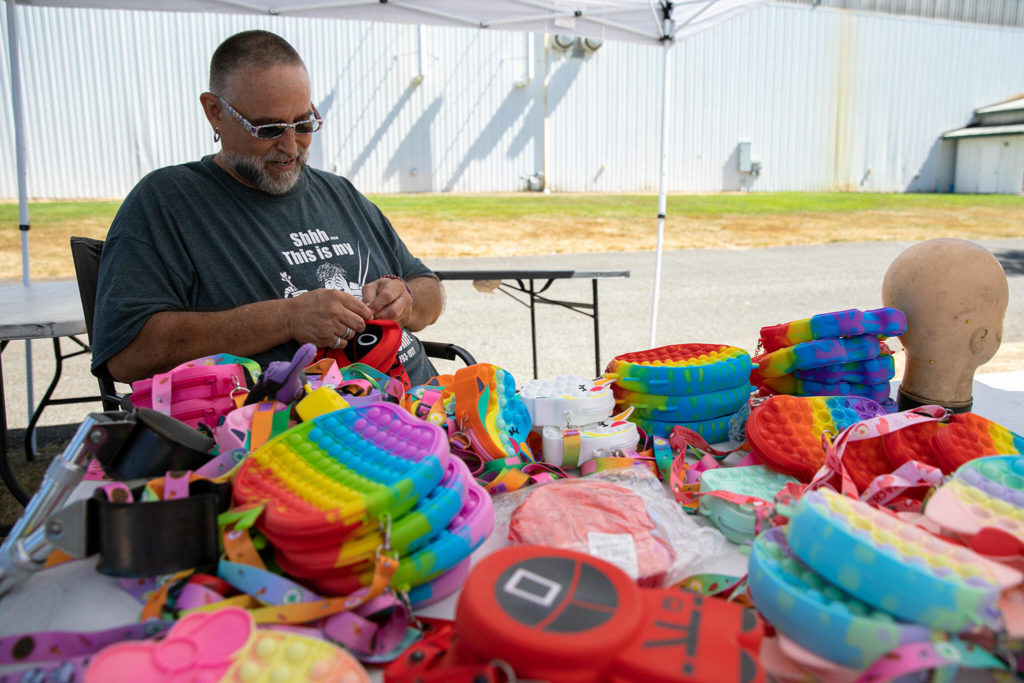 Mike Livermore, a veteran and sign language interpreter from Sultan, prepares toys for sale at his booth Monday, at the Evergreen State Fairgrounds in Monroe. Livermore said he’s been working the fair for four years now because he likes meeting people that pass through and it gets him out of the house. (Ryan Berry / The Herald)

