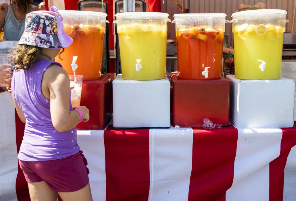 A young girl fills up a cup with strawberry lemonade during opening day of the Evergreen State Fair on Thursday, in Monroe. (Olivia Vanni / The Herald)
