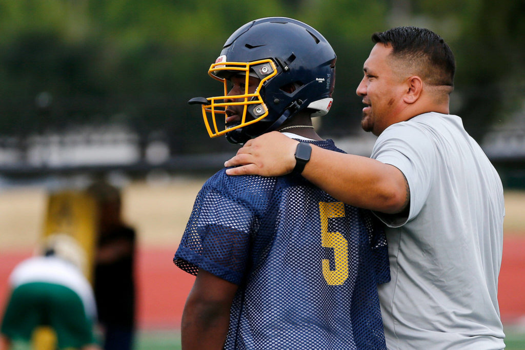 Tuiasosopo talks with senior Cartez Williams during practice. (Ryan Berry / The Herald)
