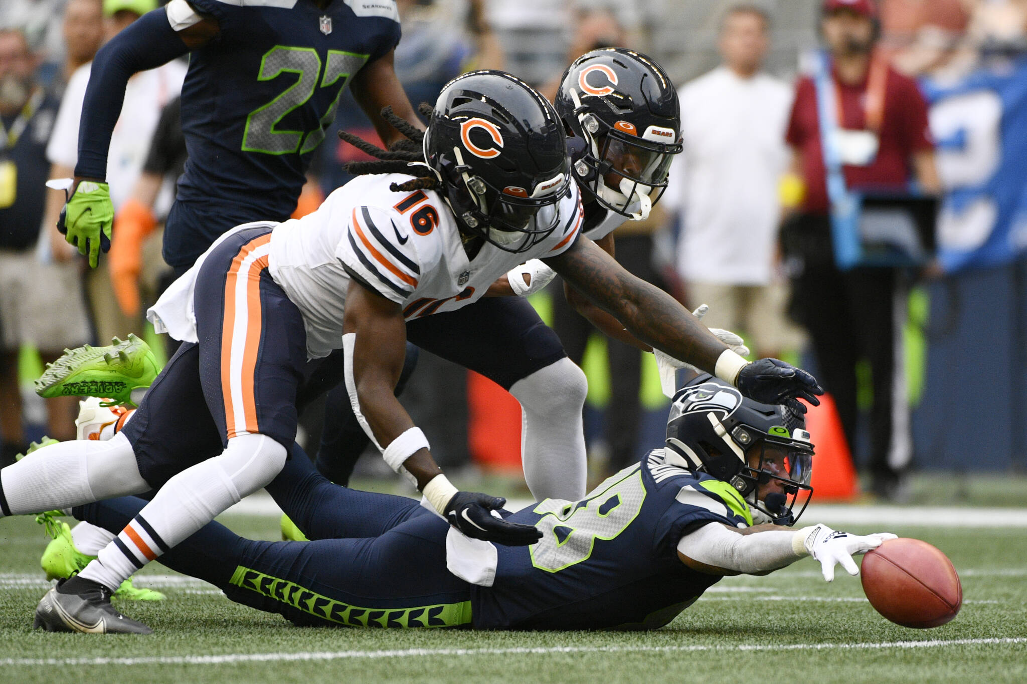 The Seahawks’ Cade Johnson (right) reaches for the ball after he fumbled on a punt return as the Bears’ Davontae Harris (16) and reaches for the ball during the first half of a preseason game Thursday in Seattle. (AP Photo/Caean Couto)