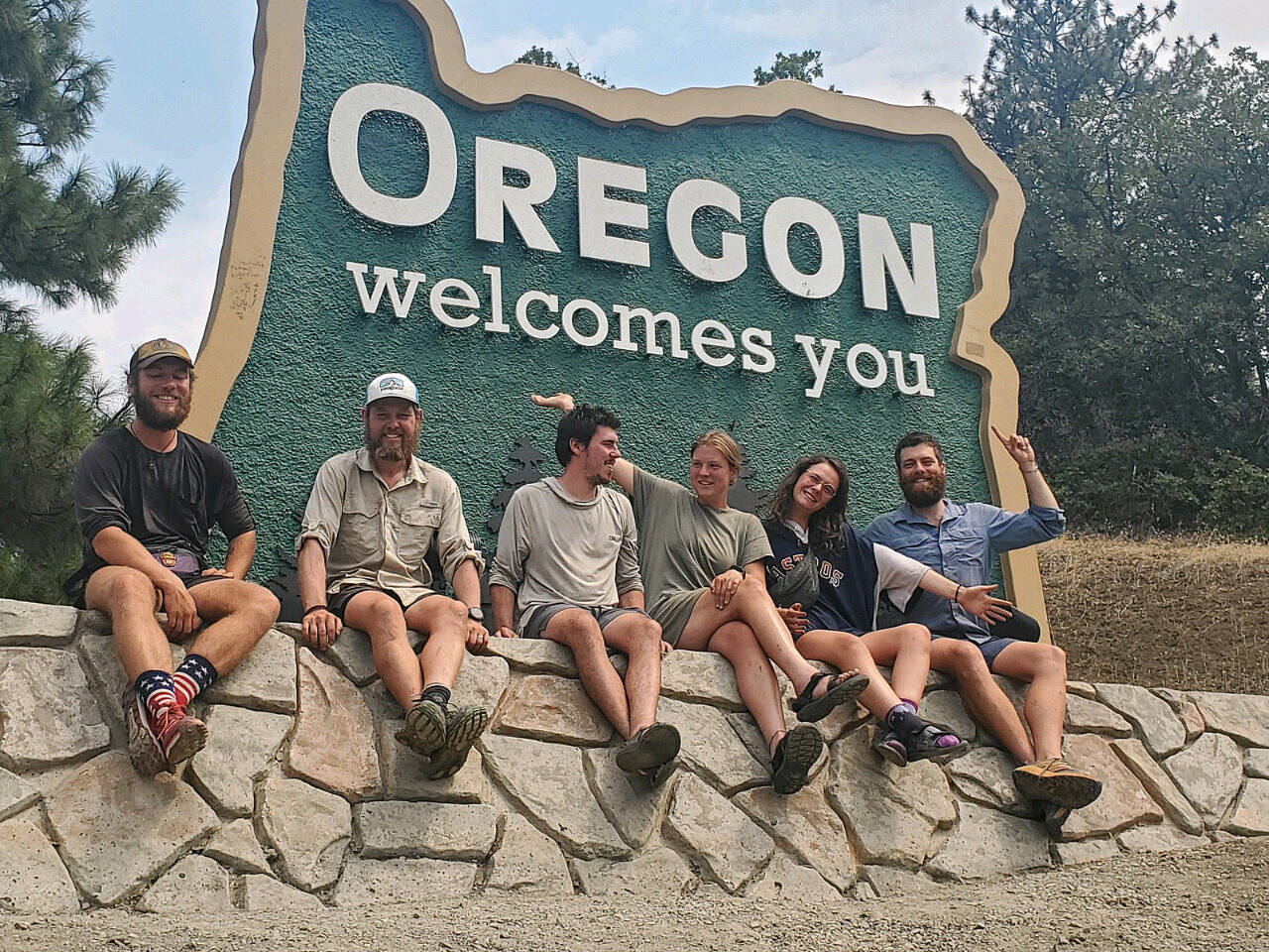Pacific Crest Trail hikers pose in front of the Oregon Welcomes You sign after crossing into Oregon from California. (The Oregonian)