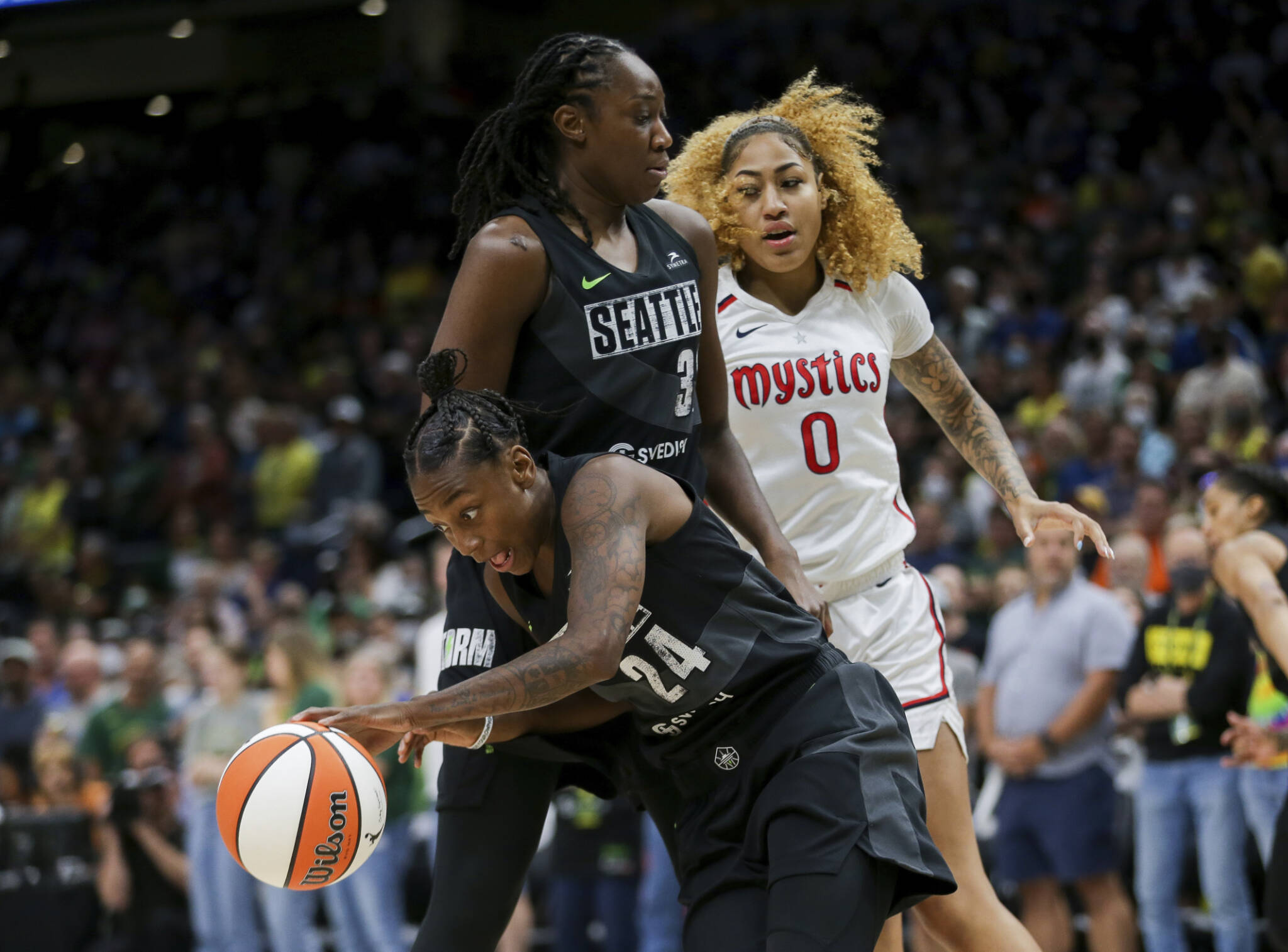 Storm guard Jewell Loyd (24) gets the rebound and makes a break around center Tina Charles (31) as Mystics center Shakira Austin (0) watches during the first half of Game 1 of a first-round playoff series Thursday in Seattle. (AP Photo/Lindsey Wasson)