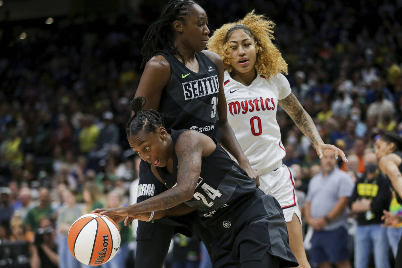 Seattle Storm guard Jewell Loyd (24) gets the rebound and makes a break around Storm center Tina Charles (31) as Washington Mystics center Shakira Austin (0) watches during the first half of Game 1 of a WNBA basketball first-round playoff series Thursday, Aug. 18, 2022, in Seattle. (AP Photo/Lindsey Wasson)