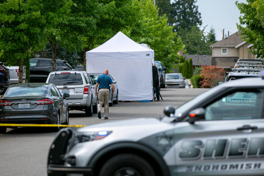 Police work on 96th Street SE where an overnight home invasion resulted in one person being killed on Friday, in Everett. (Ryan Berry / The Herald) 
