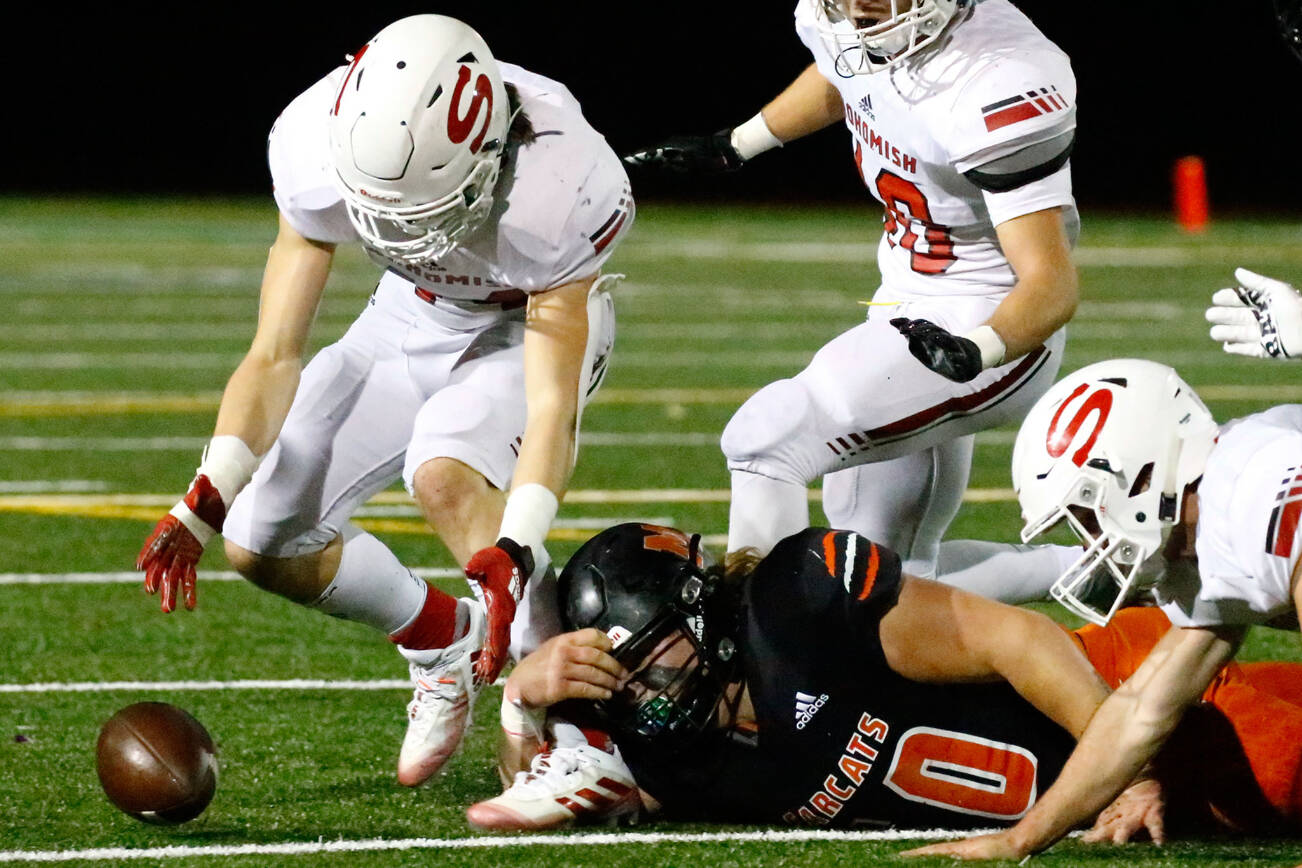 Snohomish's Kaden Alexander gathers a loose ball from a punt Friday night at Monroe High School on October 22, 2021.  (Kevin Clark / The Herald)