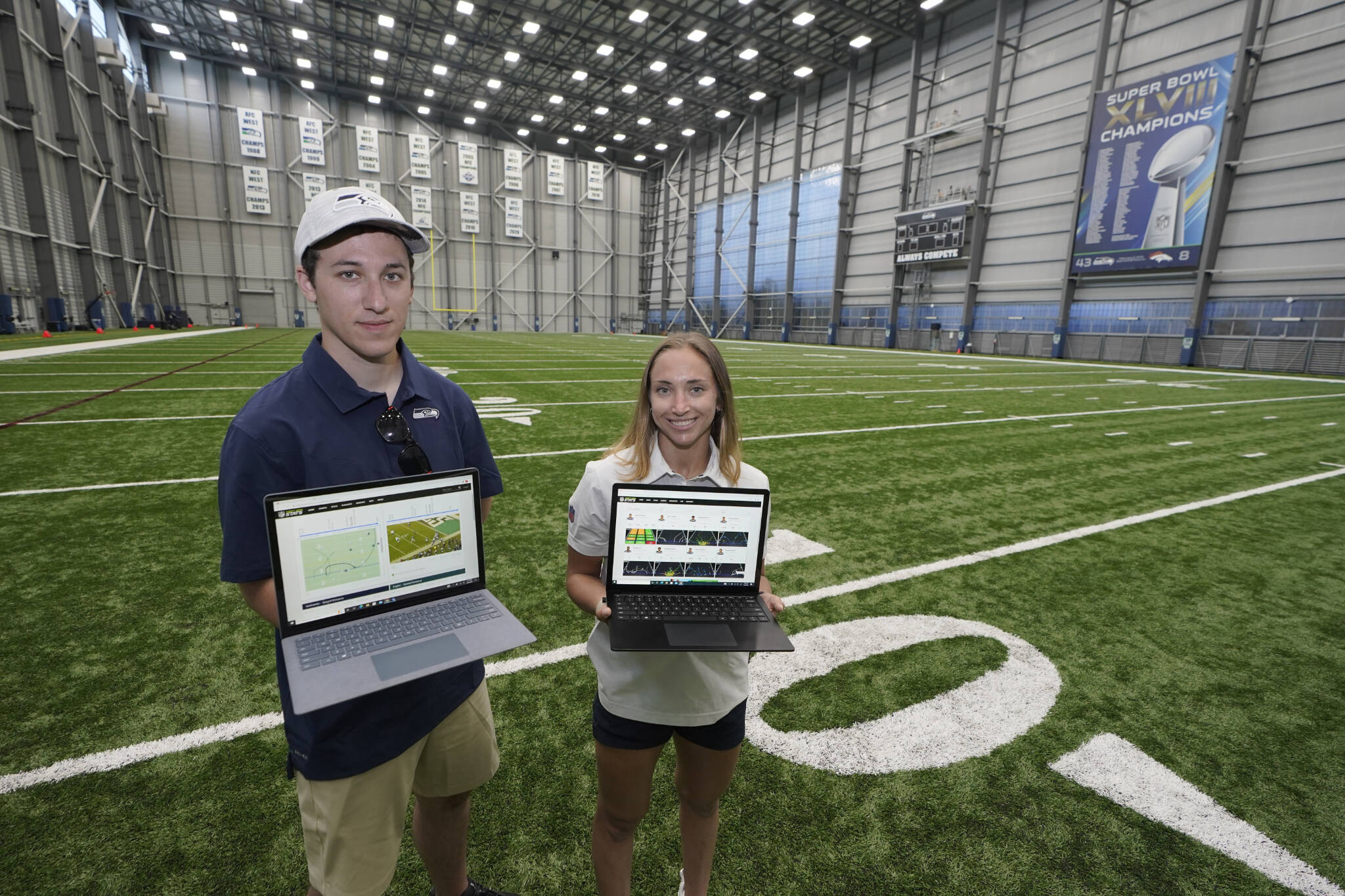 Peter Engler (left) a football research assistant, and Becca Erenbaum, a senior football research analyst, hold laptop computers at the Seattle Seahawks’ indoor training facility in Renton. (AP Photo/Ted S. Warren)