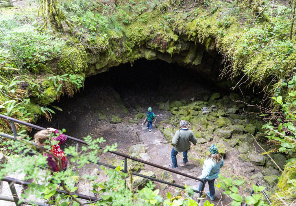 Hikers walk down into Ape Cave, which was discovered in 1942. (Taylor Balkom / The Columbian)
