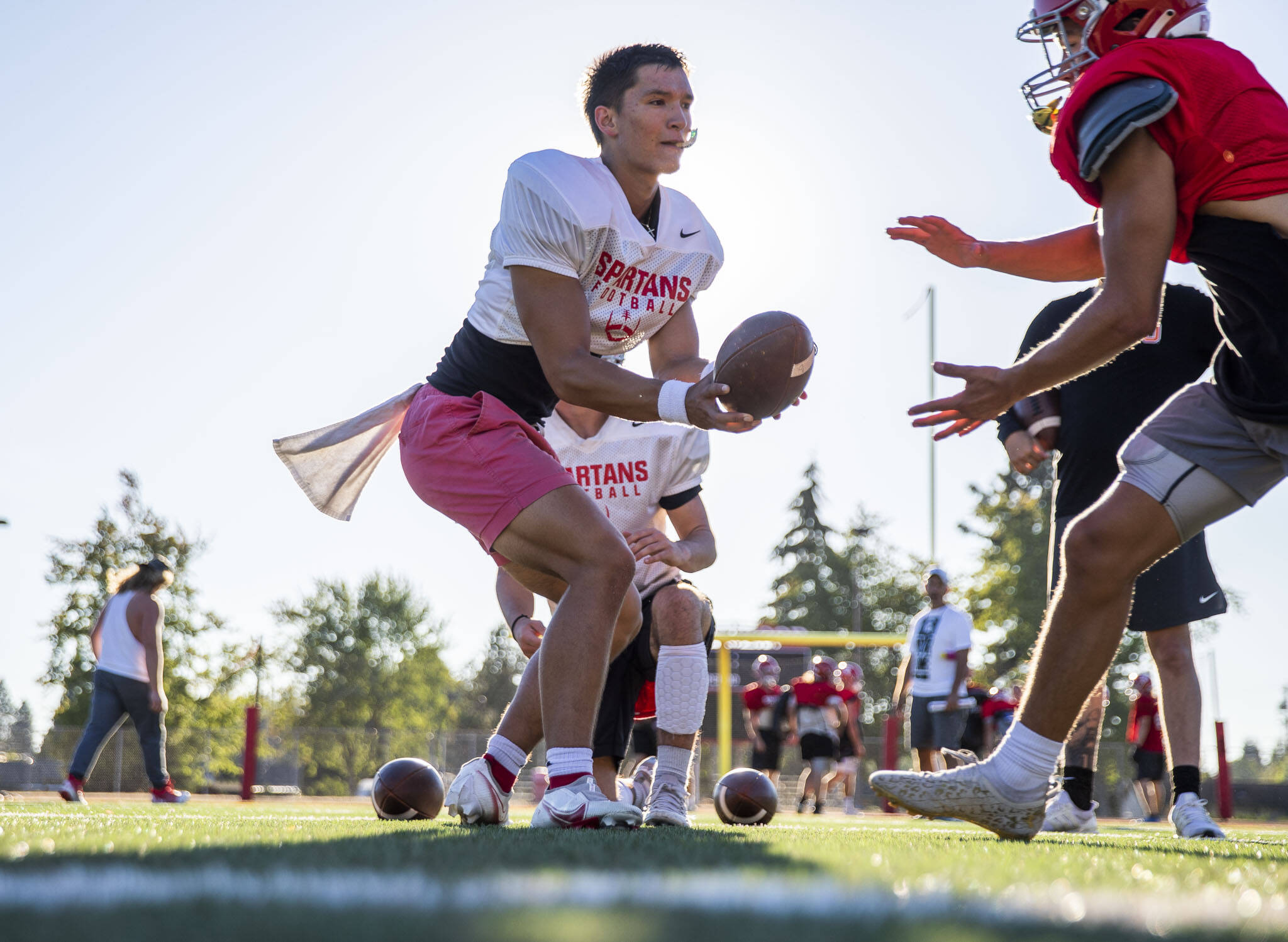 Stanwood’s Wyatt Custer works on handoffs during practice Monday, Aug. 29, 2022 in Stanwood. (Olivia Vanni / The Herald)