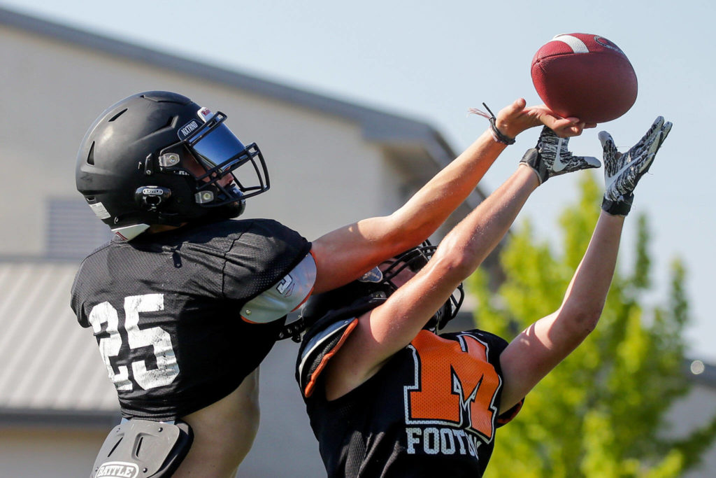 Trent Bublitz, left and Braden Bingham jump for a reception during practice at Monroe High School Tuesday afternoon in Monroe, Washington on August 30, 2022. (Kevin Clark / The Herald)
