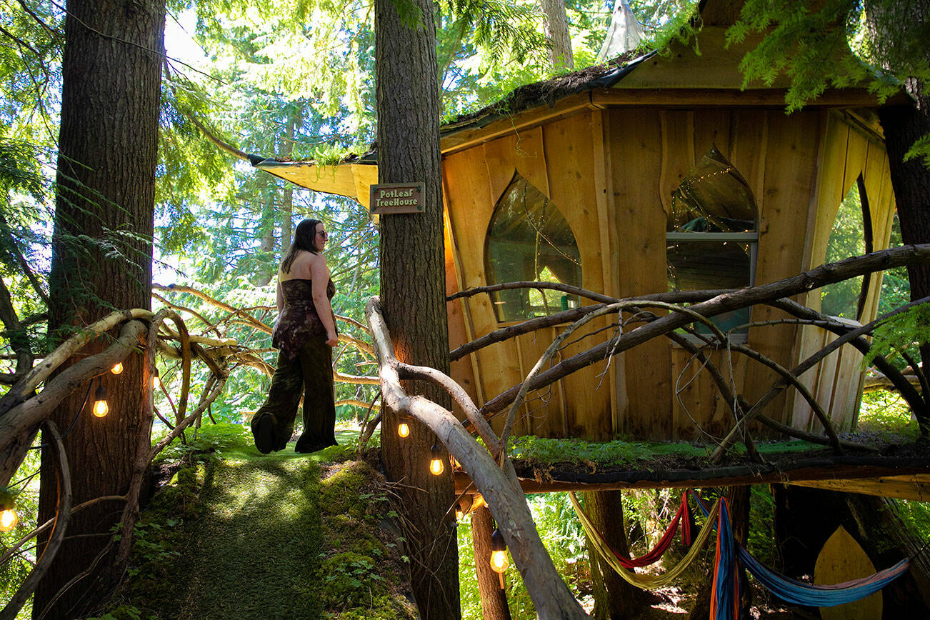 Owner and operator Tracy Rice walks up the ramp to the Potleaf Treehouse, one of four available for booking, on Wednesday, July 20, 2022, at Mountain View’s Treehouse Joint in Monroe, Washington. (Ryan Berry / The Herald)