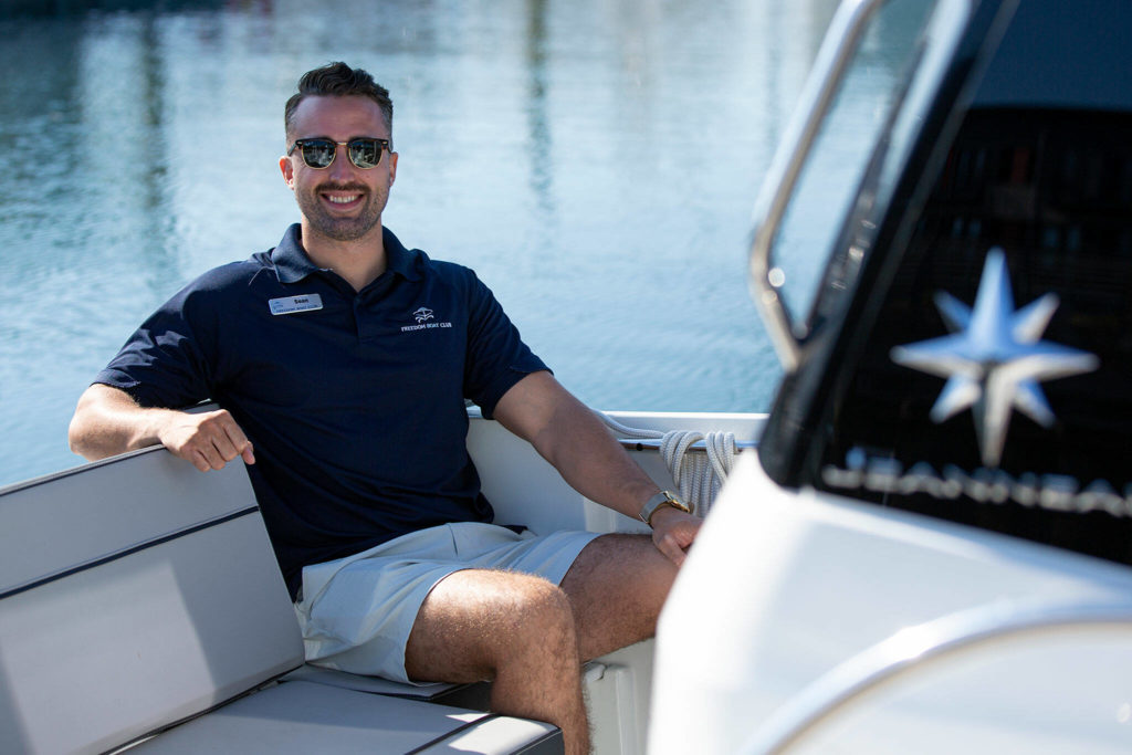 Sean Jones, membership executive of Everett’s Freedom Boat Club, sits in one of the clubs vessels for a photo on Aug. 11, at the Port of Everett in Everett. (Ryan Berry / The Herald)
