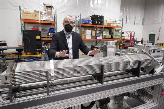 Chris Levesque, president and CEO of TerraPower, a company developing and building small nuclear reactors, displays a fuel assembly model on Jan. 13, in Everett. The 5-foot model is about one-third actual length and would be vertical when in use, rather than horizontal. By cooling the reactor with liquid sodium, a metal that solidifies at well above room temperature, TerraPower says its relatively small, 345-megawatt plant will be safe and less expensive than conventional, water-cooled nuclear plants. (AP Photo / Elaine Thompson)

