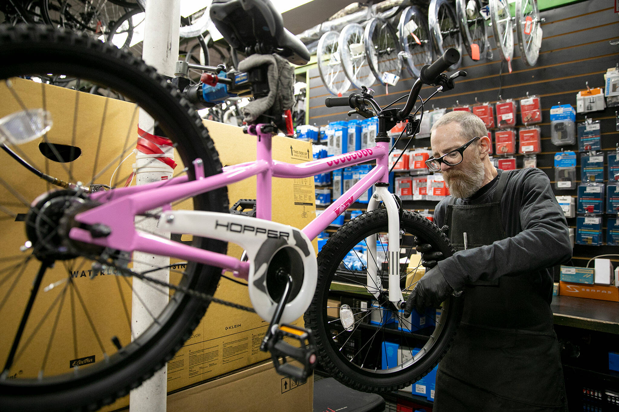 Mechanic Ron Bishop wrenches on a children’s bike while working Thursday, Sep. 1, 2022, at Bicycle Centres of Silverlake in Everett, Washington. (Ryan Berry / The Herald)