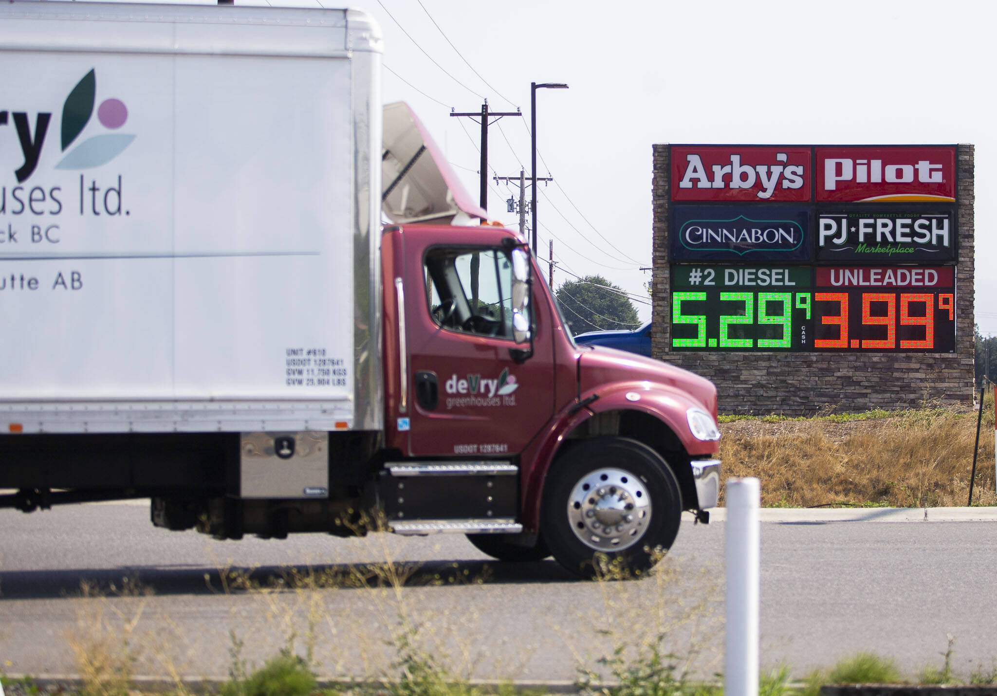 A truck drives past a sign displaying fuel prices on Sept. 2, in Arlington. (Olivia Vanni / The Herald)