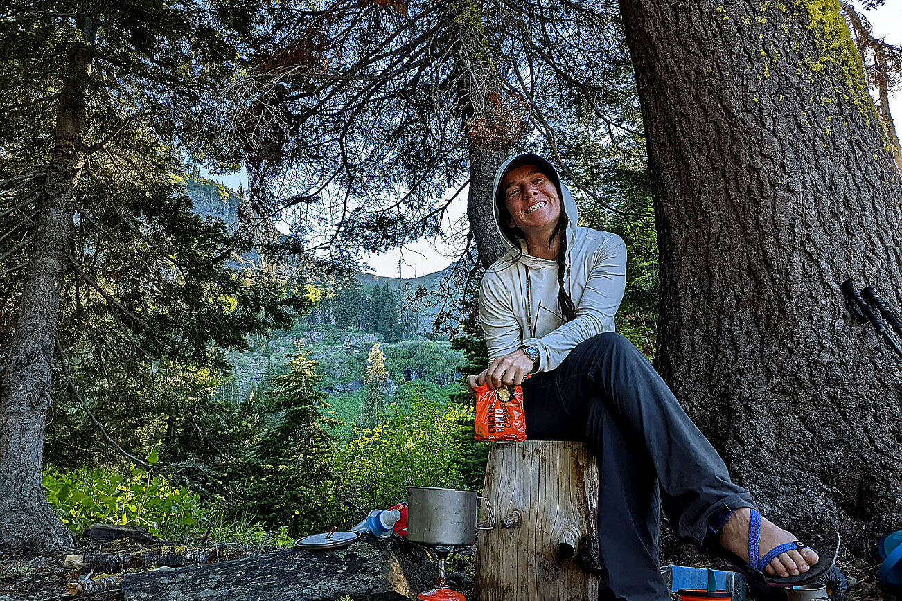 PCT thru-hiker Manny pulls out a hot pizza at Washington Alpine Club’s Guye Cabin near Snoqualmie Pass on Wednesday, Aug. 17, 2022. (Taylor Goebel / The Herald)