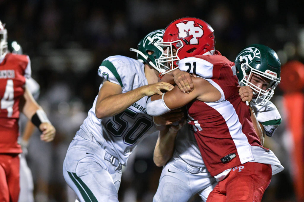 Edmonds-Woodway defenders gang up to tackle Marysville Pilchuck’s Kenai Sinaphet (21) during a game on Friday, Sept. 2, 2022, at Marysville Pilchuck High School. (John Gardner/Pro Action Image)
