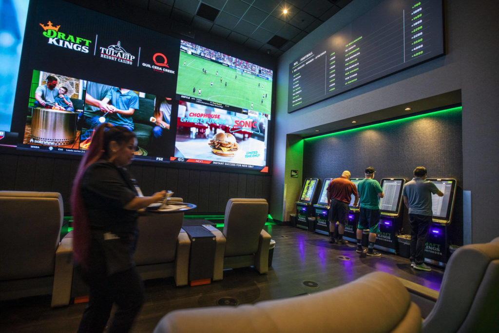 People lineup to place bets at the kiosks during the soft opening of the DraftKings Sportsbook at the Tulalip Casino on Tuesday, in Tulalip. (Olivia Vanni / The Herald)
