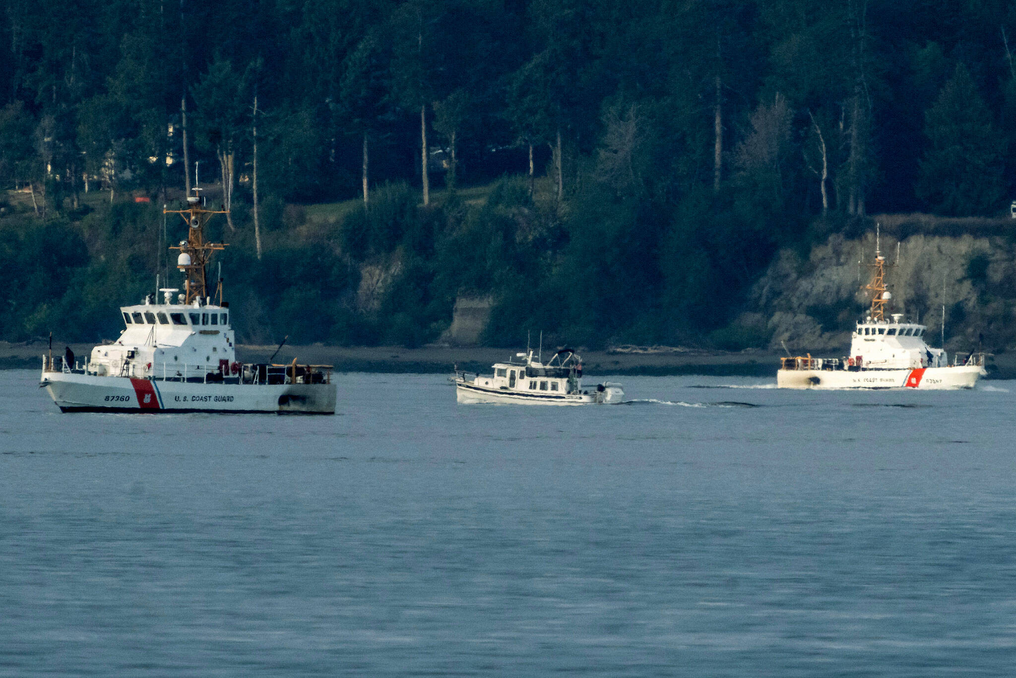 A pair of U.S. Coast Guard vessels search the area, Monday, near Freeland, on Whidbey Island north of Seattle where a chartered floatplane crashed the day before. The plane was en route from Friday Harbor to Renton. (AP Photo / Stephen Brashear)