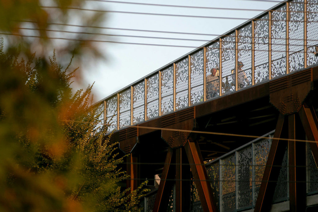 Pedestrians walk along the top of the Grand Ave Park Bridge on Wednesday, in Everett. (Ryan Berry / The Herald)
