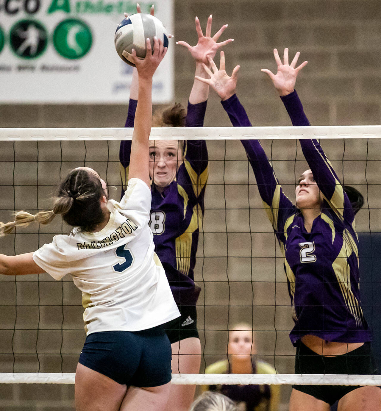 Arlington’s Reese Remle attempts a kill with Lake Stevens’ Peri Hoshock (8) and Bella Christensen (2) blocking in the first set Tuesday evening at Arlington High School in Arlington, Washington on September 6, 2022. The Vikings won the straight sets. (Kevin Clark / The Herald)