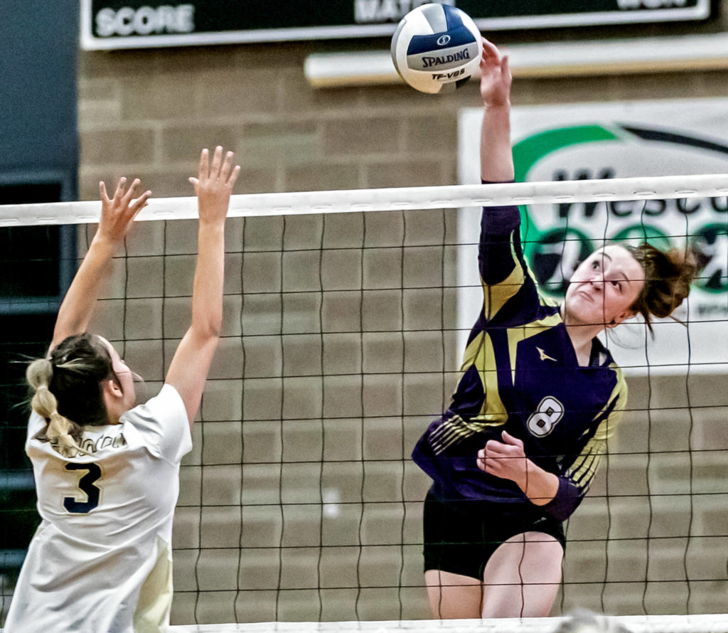 Lake Stevens’ Peri Hoshock, right, attempts a kill with Arlington’s Reese Remle blocking Tuesday evening at Arlington High School in Arlington, Washington on September 6, 2022. The Vikings won the straight sets. (Kevin Clark / The Herald)
