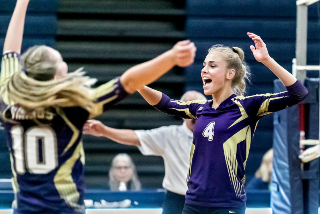 Lake Stevens’ Katelyn Eichert, left, and Laura Eichert cheer a point against the Eagles Tuesday evening at Arlington High School in Arlington, Washington on September 6, 2022. The Vikings won the straight sets. (Kevin Clark / The Herald)
