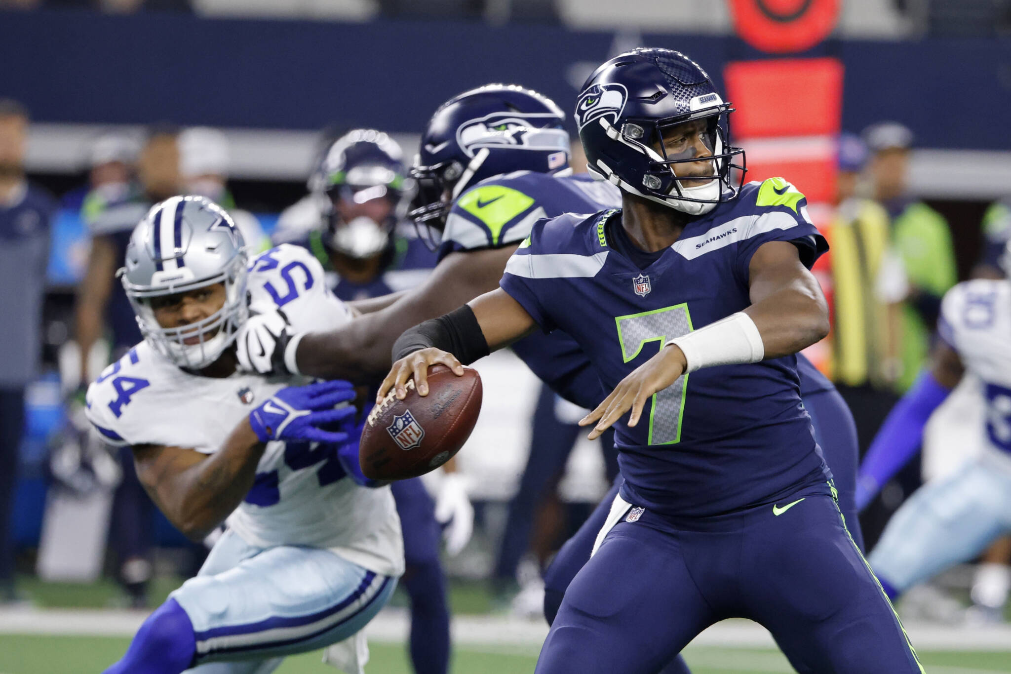 Seahawks quarterback Geno Smith (7) prepares to throw a pass under pressure from Cowboys defensive end Sam Williams (54) in the first half of a preseason game on Aug. 26, 2022, in Arlington, Texas. (AP Photo/Ron Jenkins)