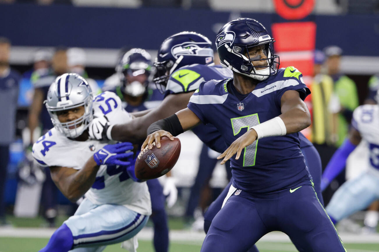 Seattle Seahawks quarterback Geno Smith (7) prepares to throw a pass under pressure from Dallas Cowboys defensive end Sam Williams (54) in the first half of a preseason NFL football game in Arlington, Texas, Friday, Aug. 26, 2022. (AP Photo/Ron Jenkins)