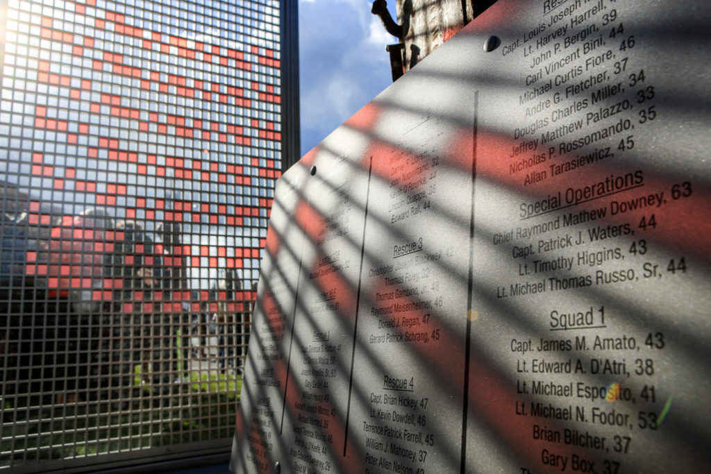 Morning sun streams through a portion of The Fallen Firefighter Memorial highlighting names of the fallen in Edmonds on Sept. 11, 2016. (Kevin Clark / The Herald)
