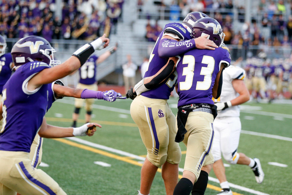 David Brown (33) celebrates with his Lake Stevens teammates after intercepting a fourth-down pass in the end zone on Bellevue’s opening drive. (Ryan Berry / The Herald)
