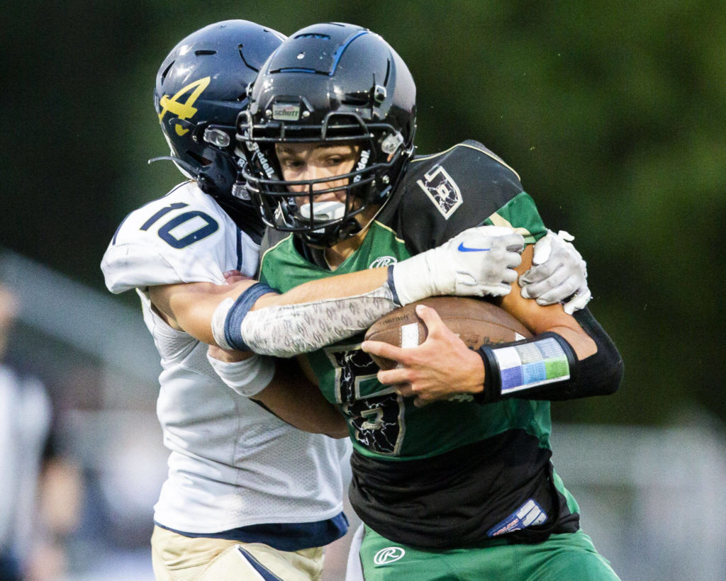 Marysville Getchell’s Carter Schmidt is tackled by Arlington’s Caiden Patterson during the game on Friday, Sept. 9, 2022 in Marysville, Washington. (Olivia Vanni / The Herald)
